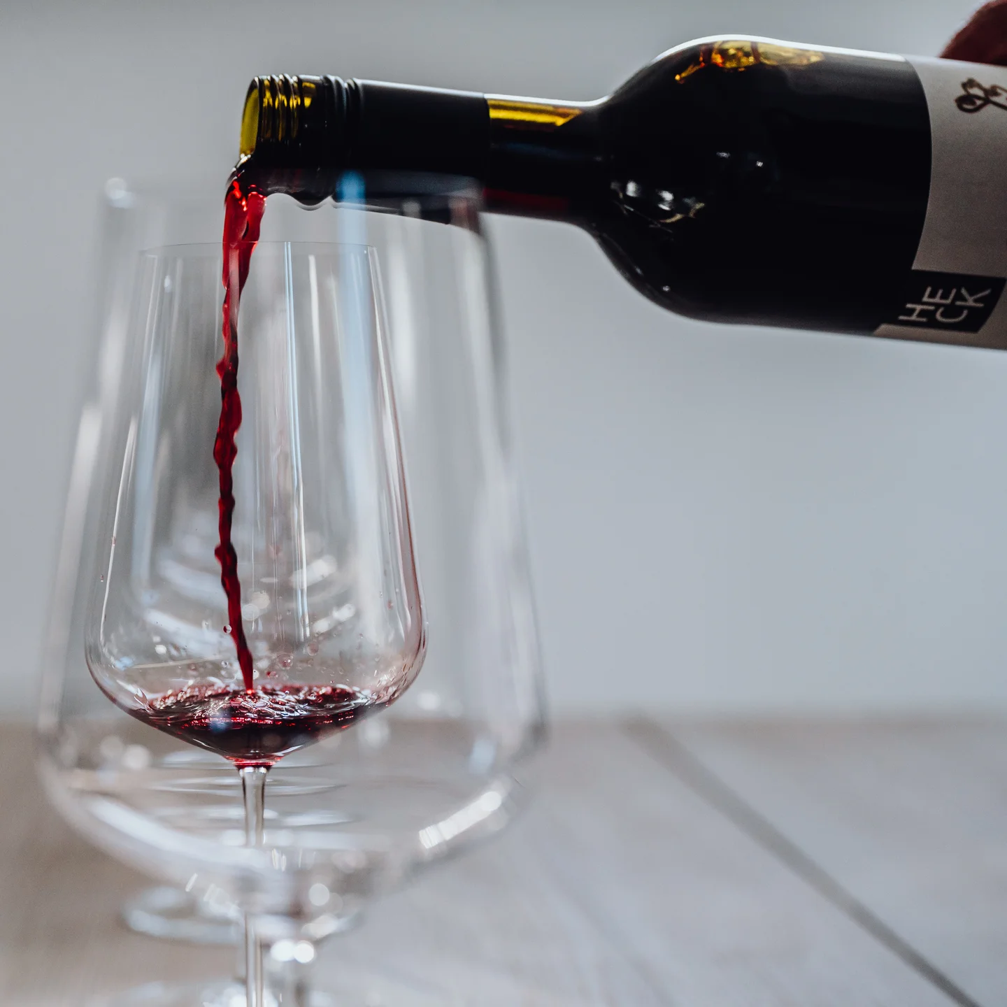 Rotwein wird aus der HECK-Flasche ins Glas eingeschenkt